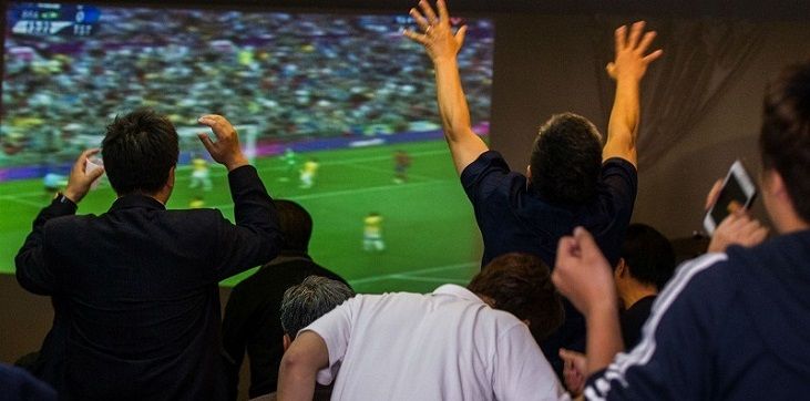 футбольный фанат смотрит трансляцию на смартфоне